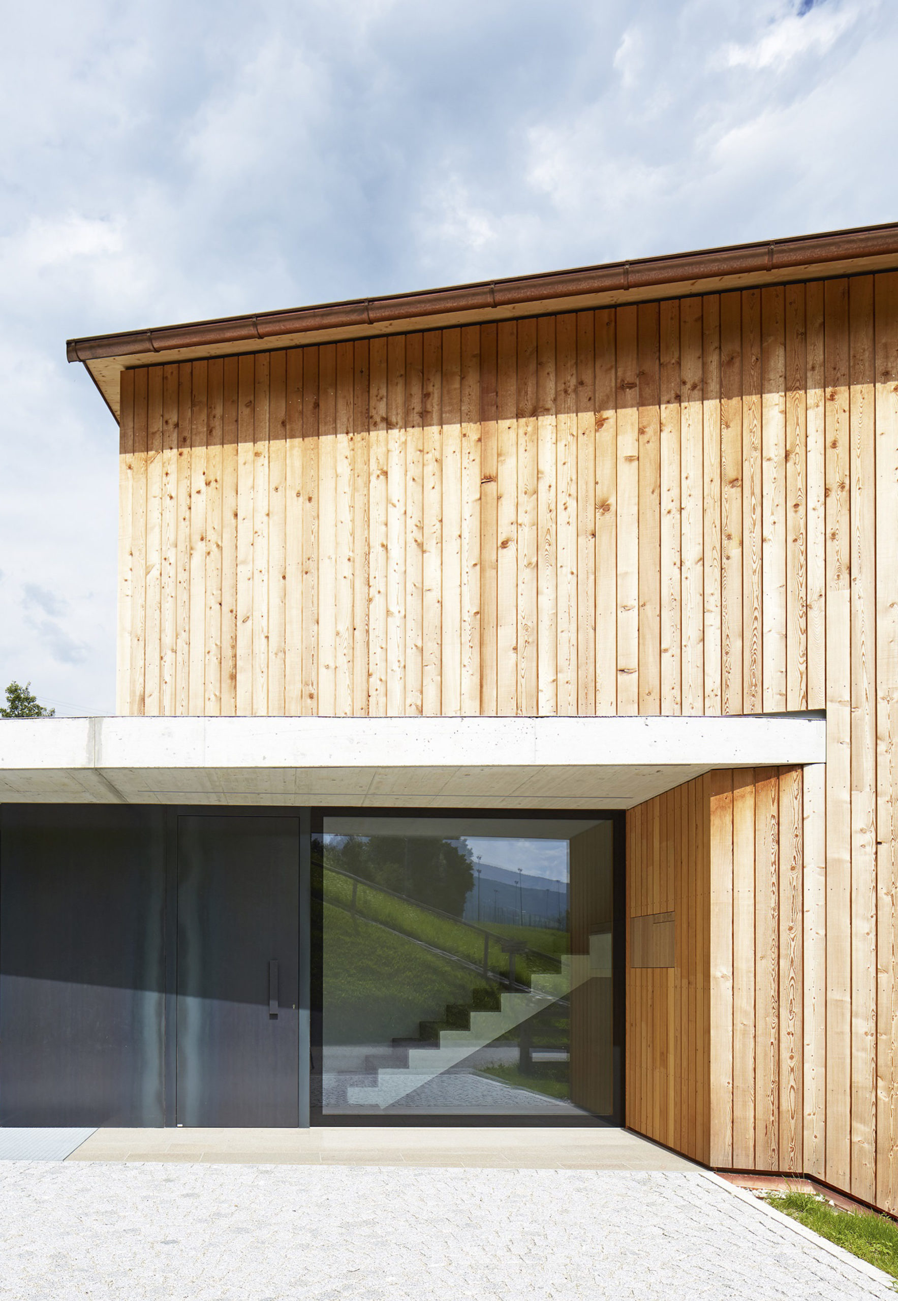  Eingang, Zugang, Sichtbeton, Außengestaltung, Garage, Holzlatten, Lärche, Natur, Kupferblech, Verglasung, Fix Glas, Landschaft, Himmel, Wolken